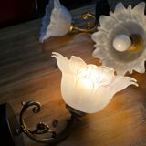 Frosted glass tulip wall sconces with brass arms.