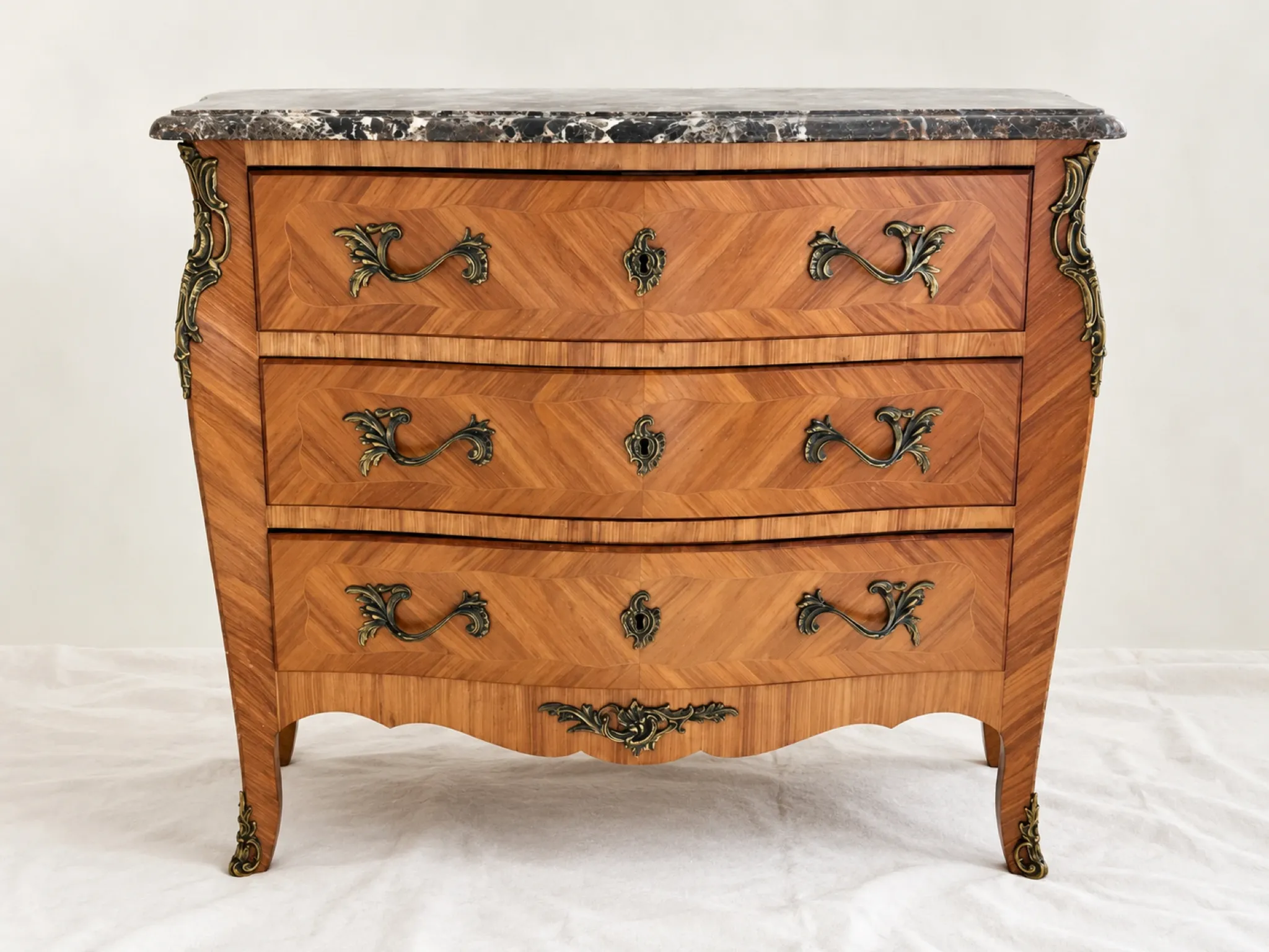 Curved Louis XV style commode in marquetry, veined marble and ornamentation.