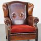 Sheepskin leather wingback chair with a red corduroy seat cushion
