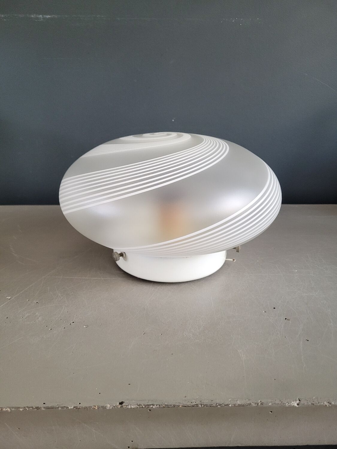 Frosted glass globe ceiling light with spiral patterns.