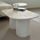 Oval coffee table in travertine and white fluted wood.