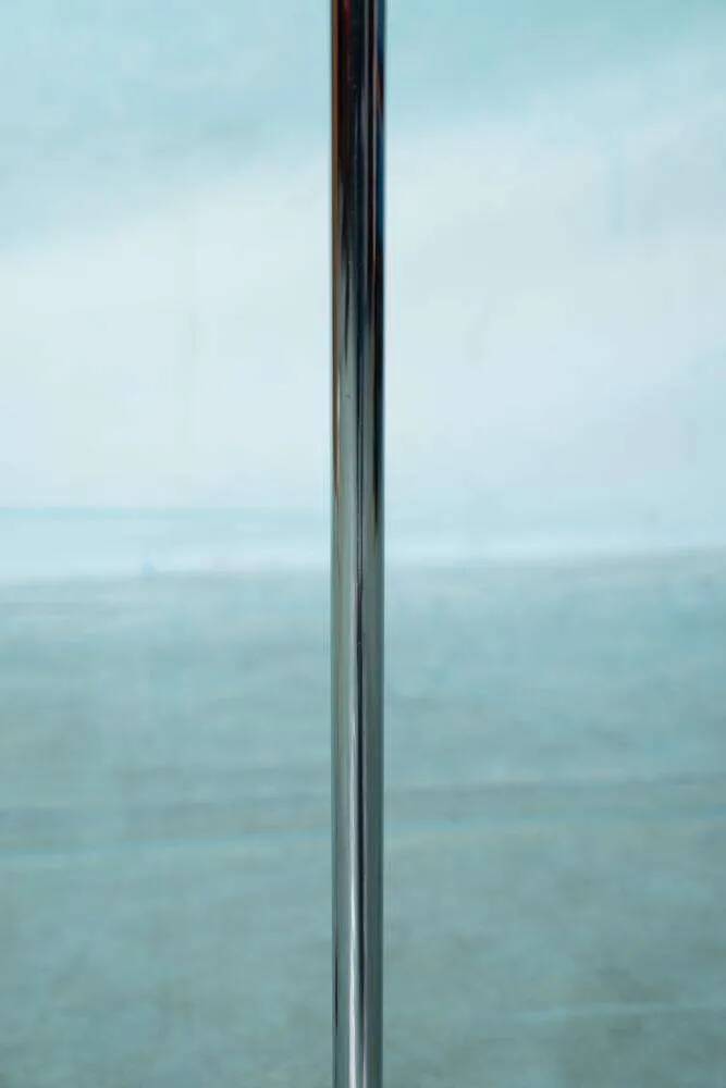 Vintage floor lamp in milky glass and chrome, minimalist uplight lighting.