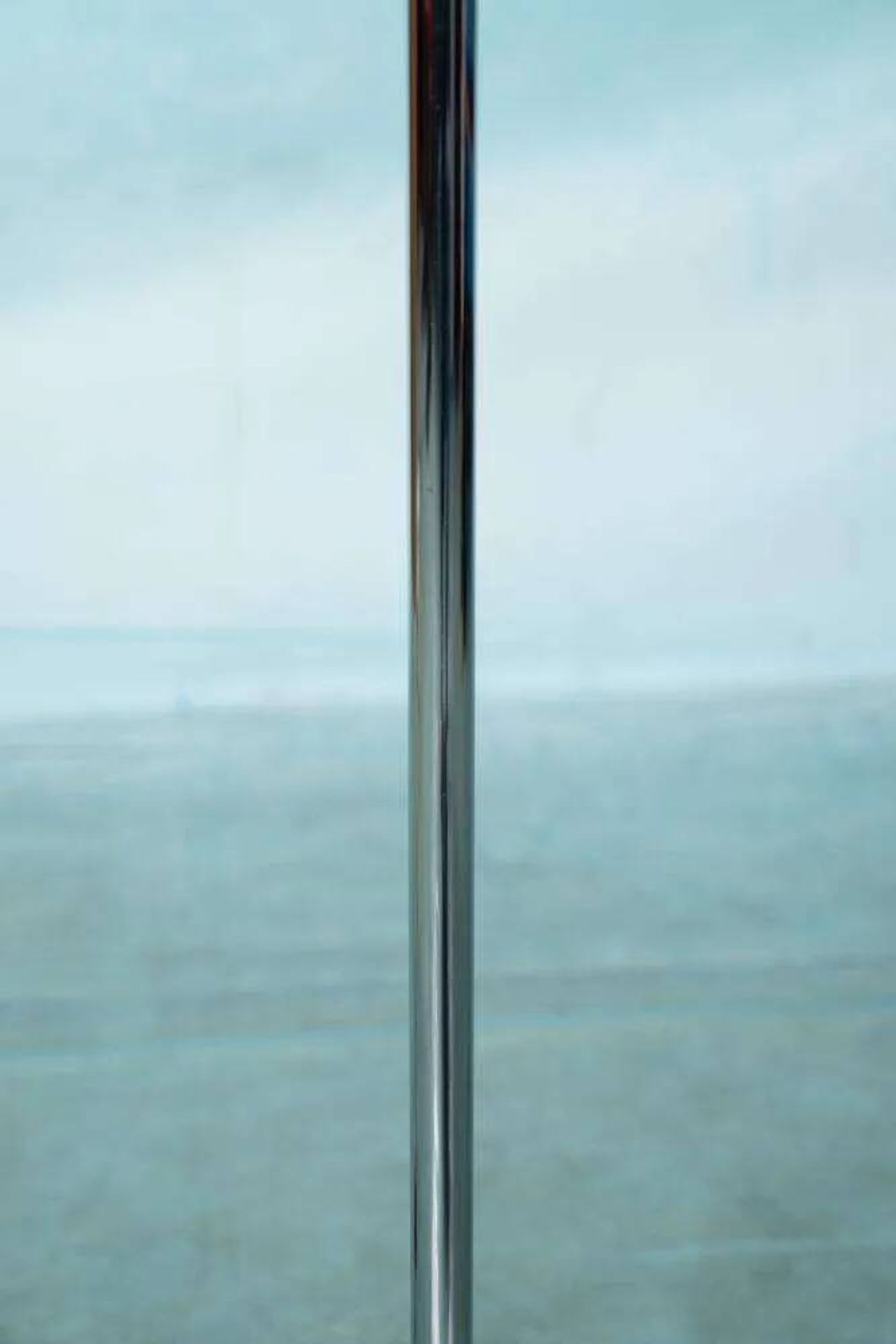 Vintage floor lamp in milky glass and chrome, minimalist uplight lighting.
