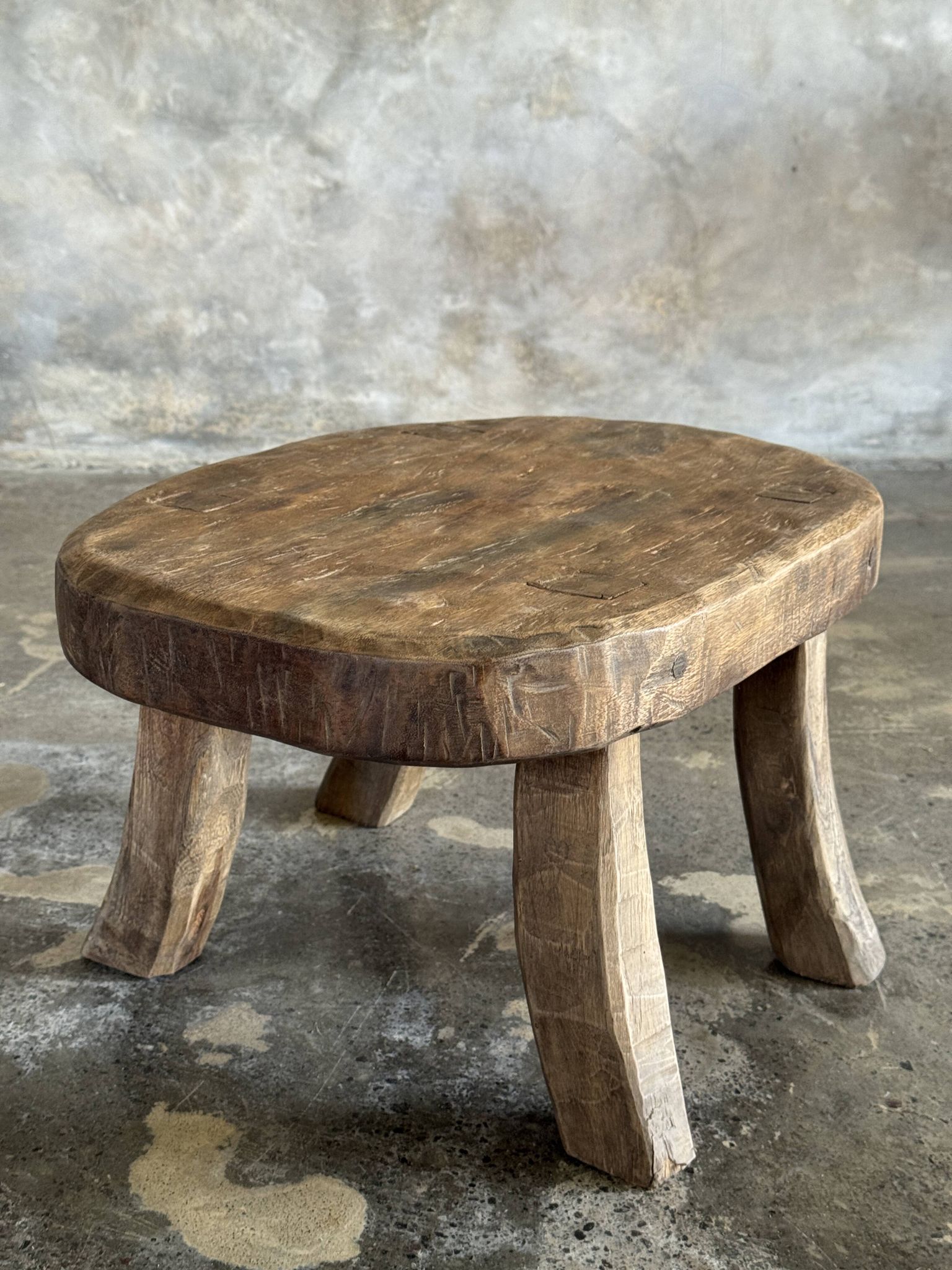 Small stool, oval solid teak side table with curved legs in wabi-sabi style.