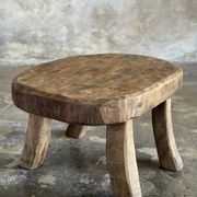 Small stool, oval solid teak side table with curved legs in wabi-sabi style.