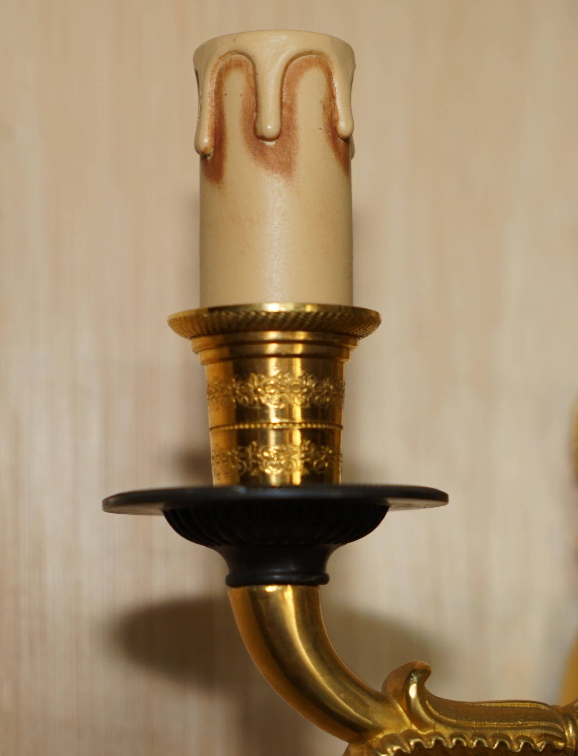 Pair of L'Originale wall sconces plated with 24-carat gold featuring four bronze candles.
