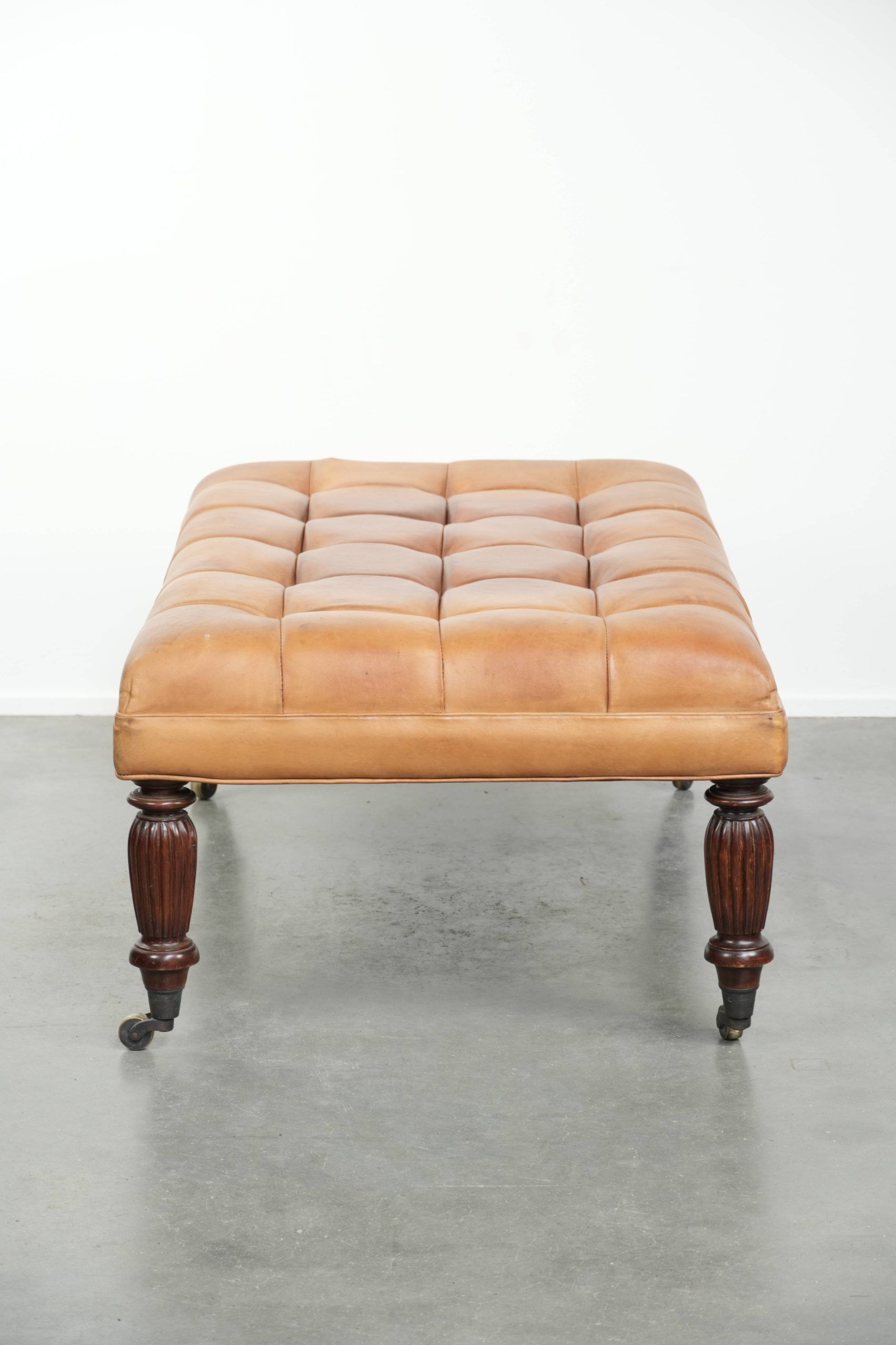 Sheepskin ottoman/coffee table on wheels in English chesterfield style