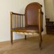 Antique armchair in solid wood and patinated brown leather, early 20th century.