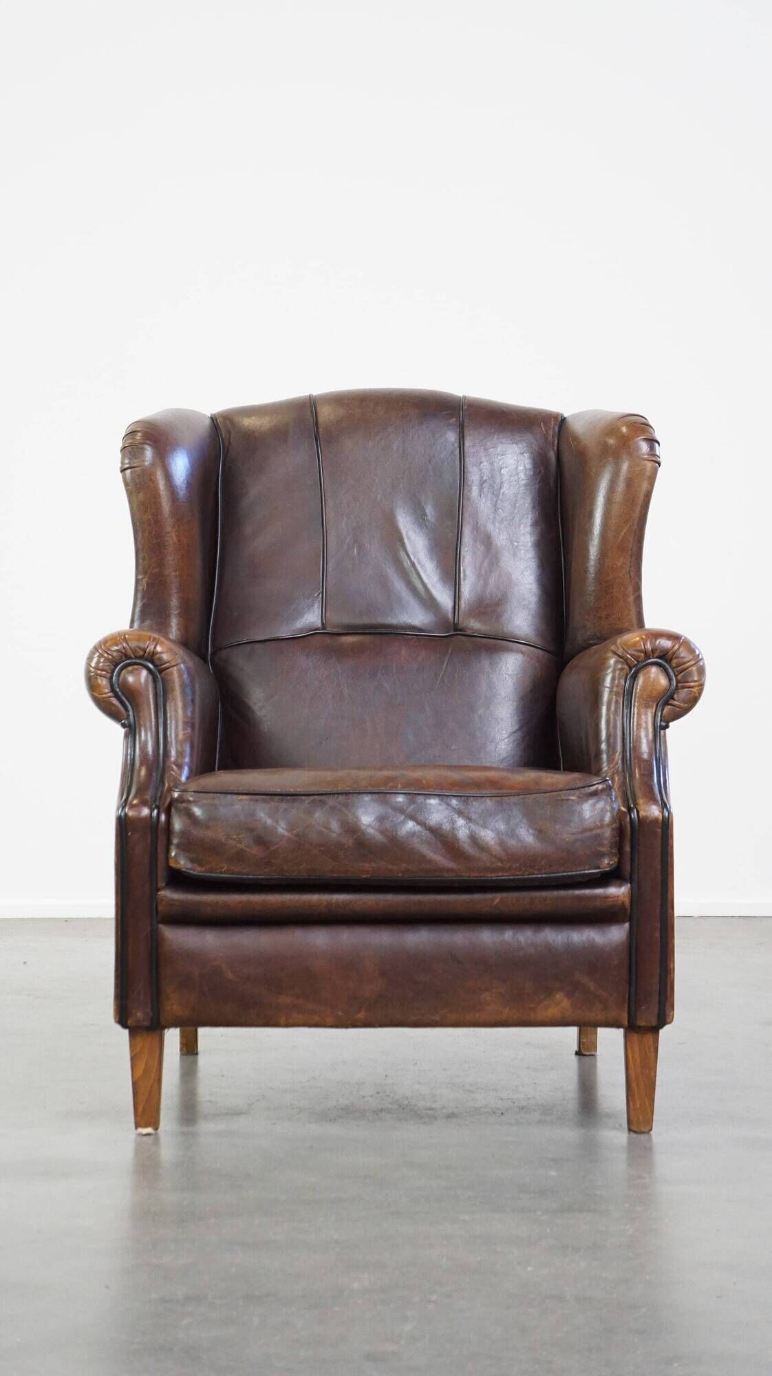 Wing chair made of sheepskin and neatly finished with black piping