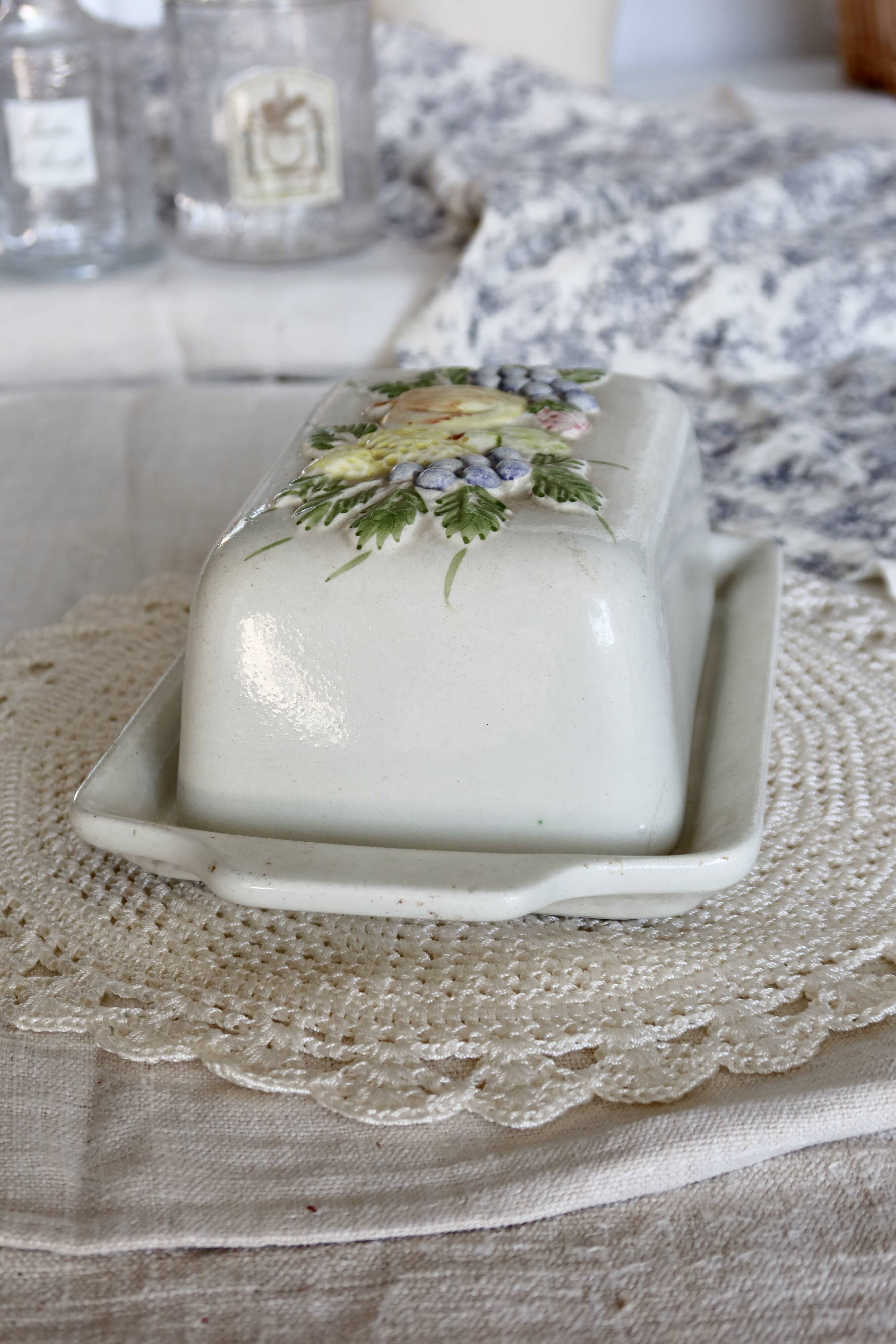 Large vintage faience butter dish with a fruit motif.