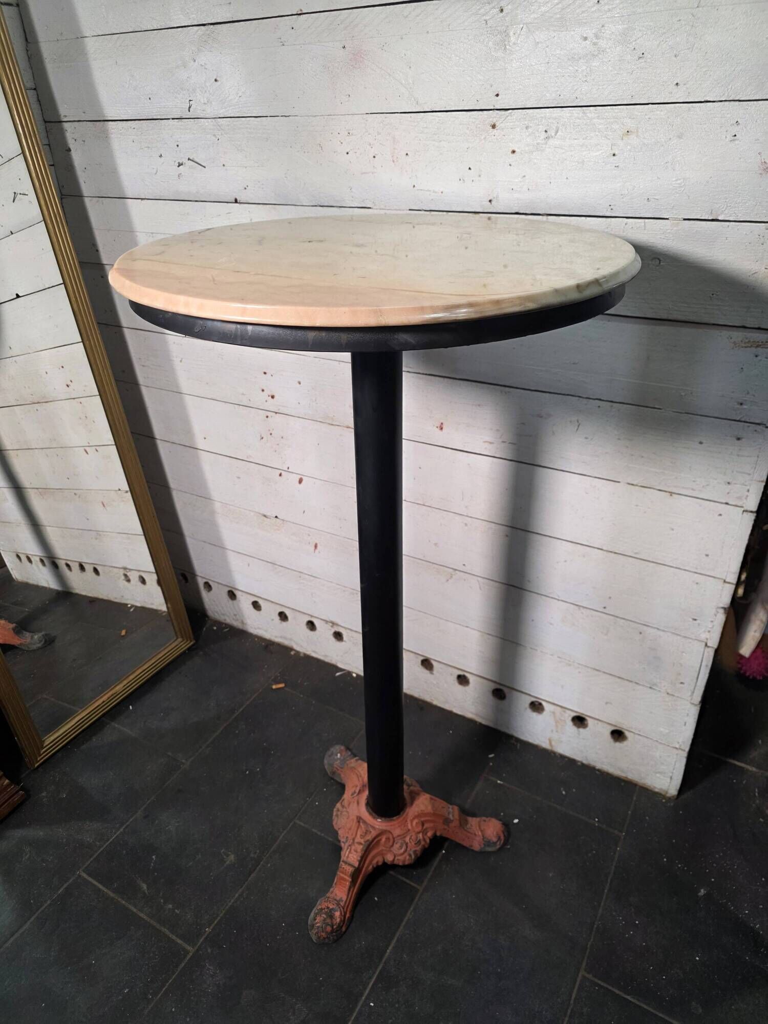 Bistro standing table with marble top and cast iron base.
