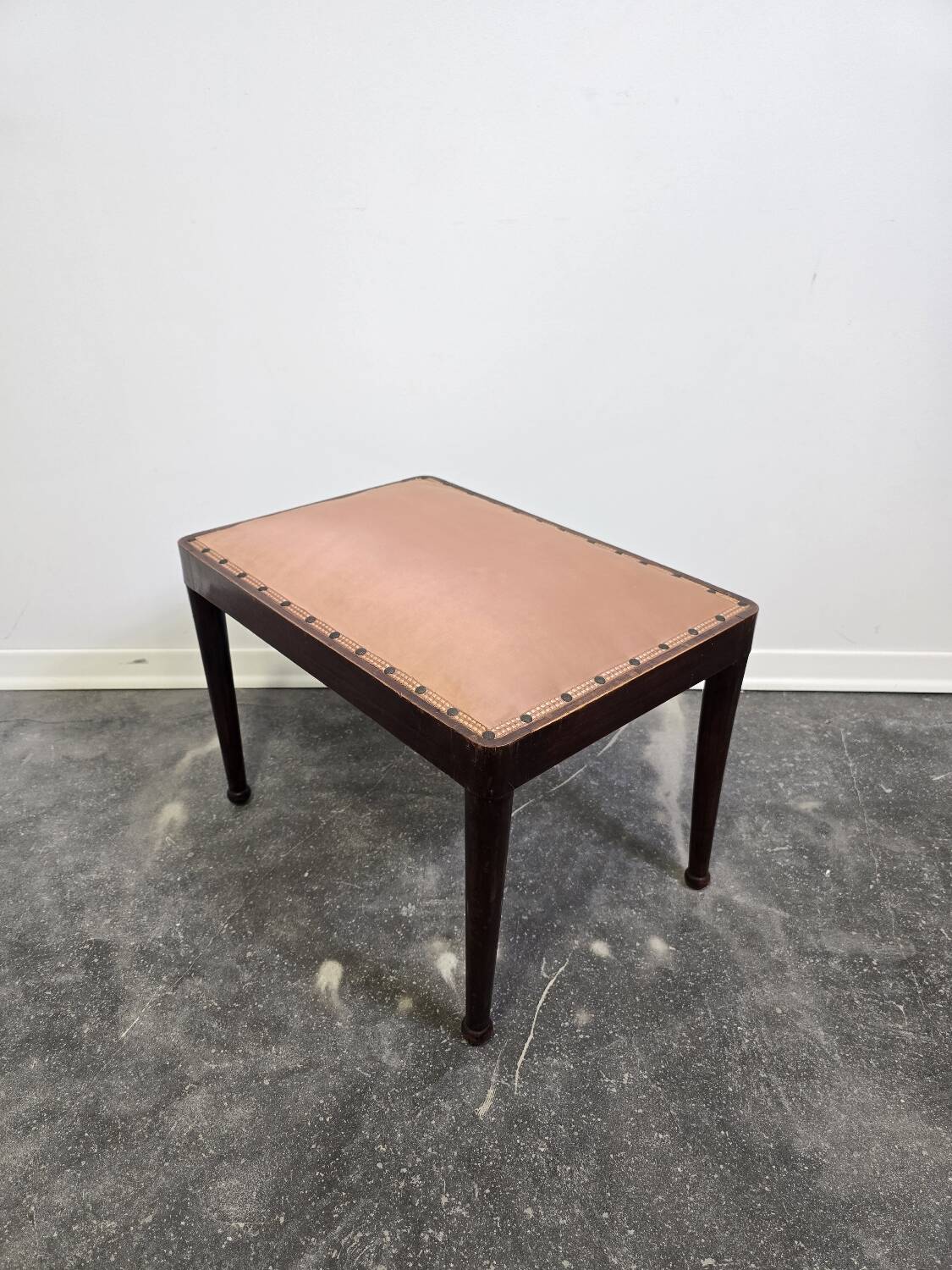 Vintage wooden ottoman from the 1940s with a silk top and studded trim.