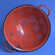 Vintage red enameled sheet metal colander