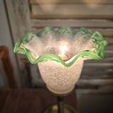 Small table lamp with a brass fish base and a tulip shade with green edges.