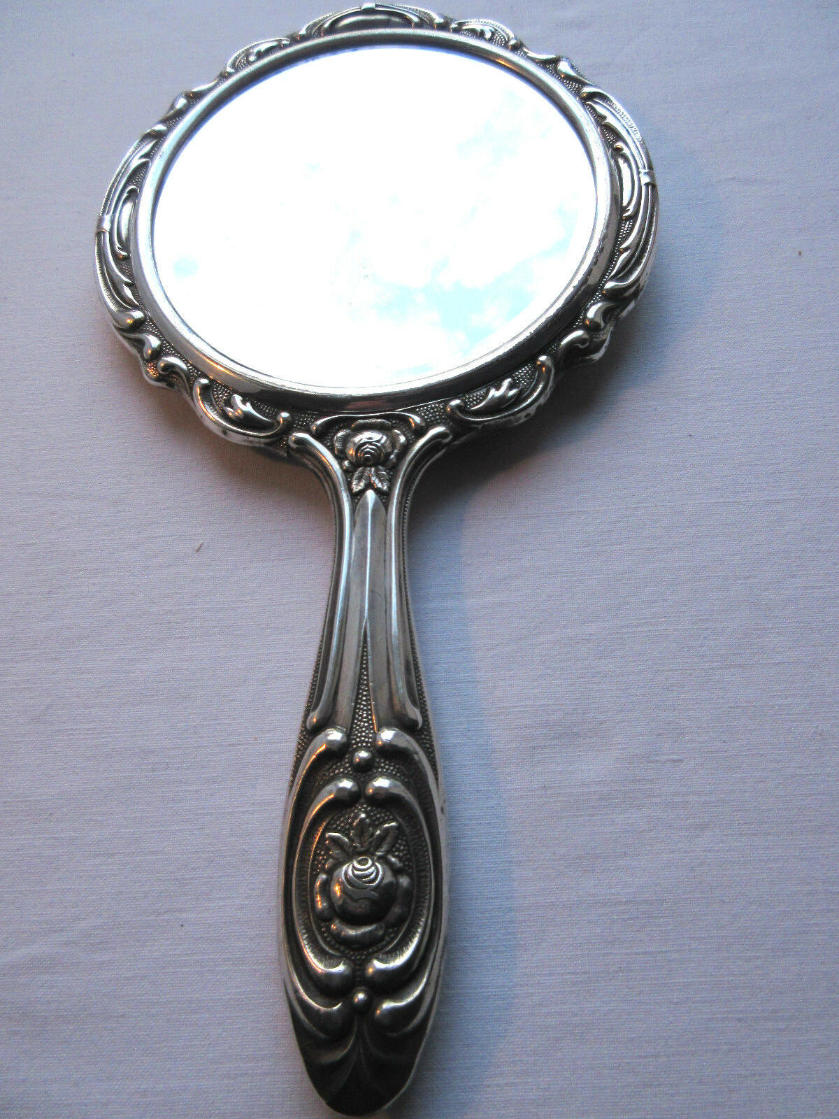 Art Nouveau hand-facing, mirror in repulsed silver frame, rose decoration 14x27cm