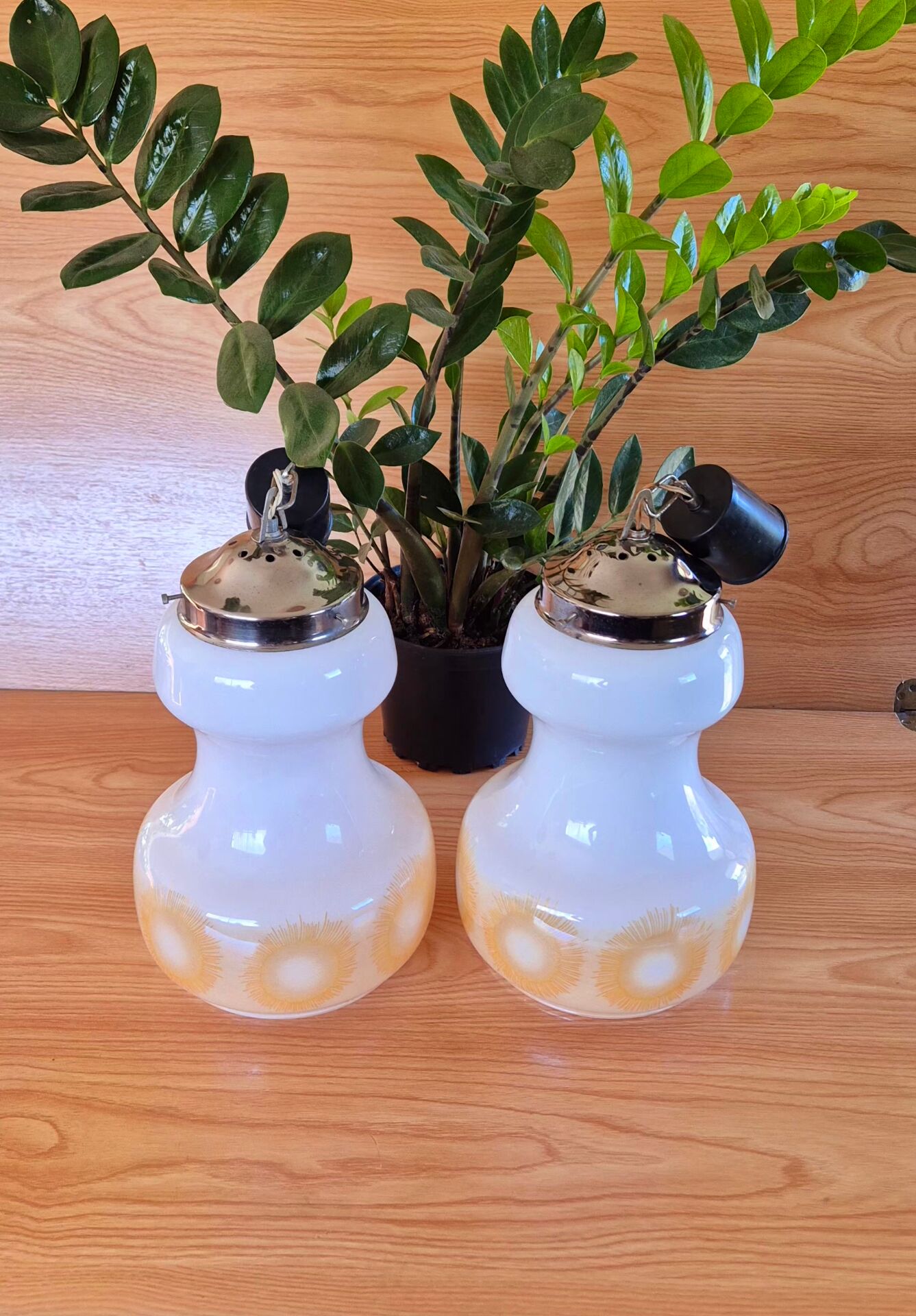 2 vintage pendant lights in white opaline with orange patterns and chrome.