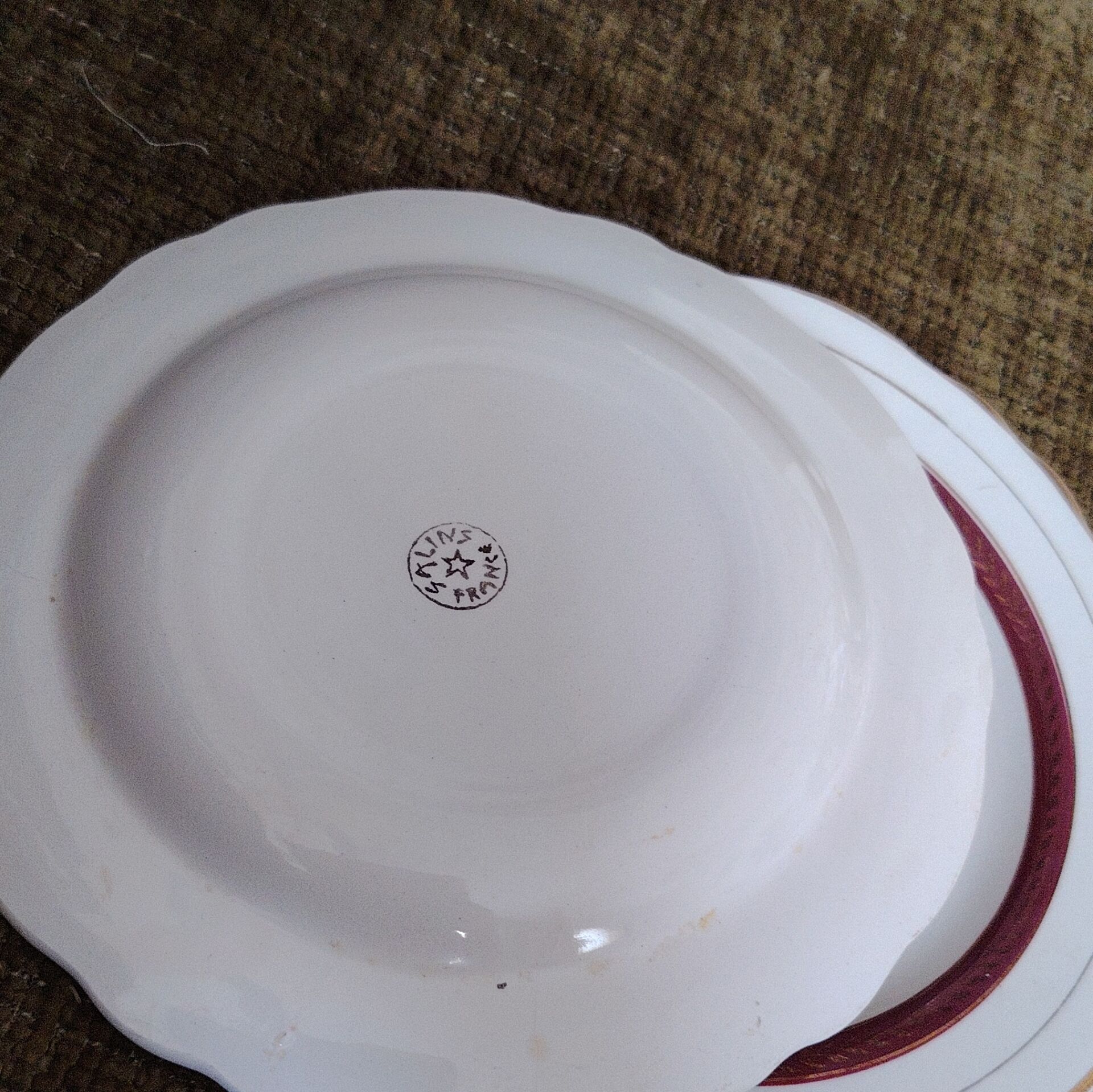Salins white ceramic dessert plates with red trim and gold rim.