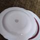 Salins white ceramic dessert plates with red trim and gold rim.