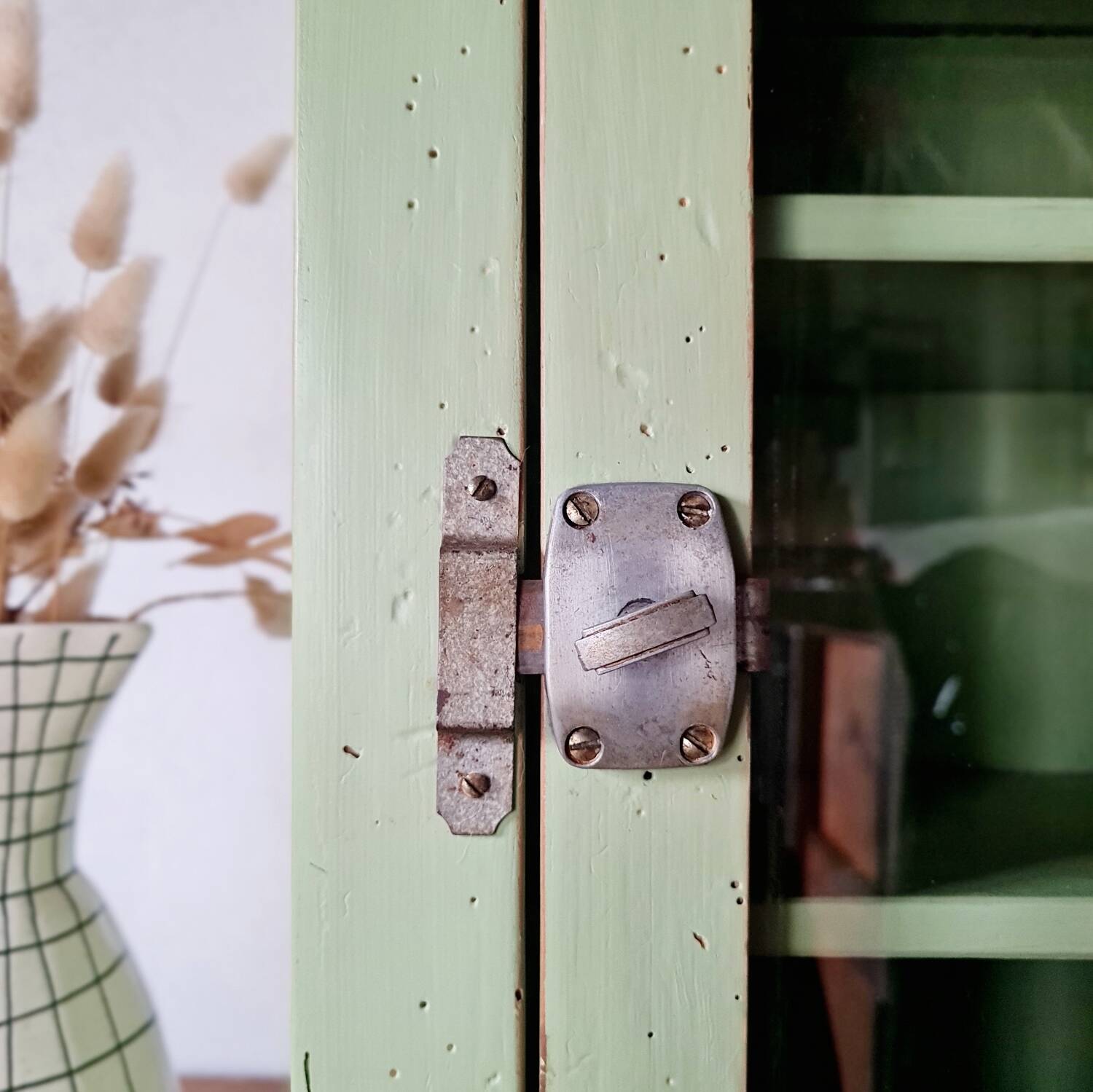Small glass cabinet in green colour.