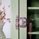 Small glass cabinet in green colour.