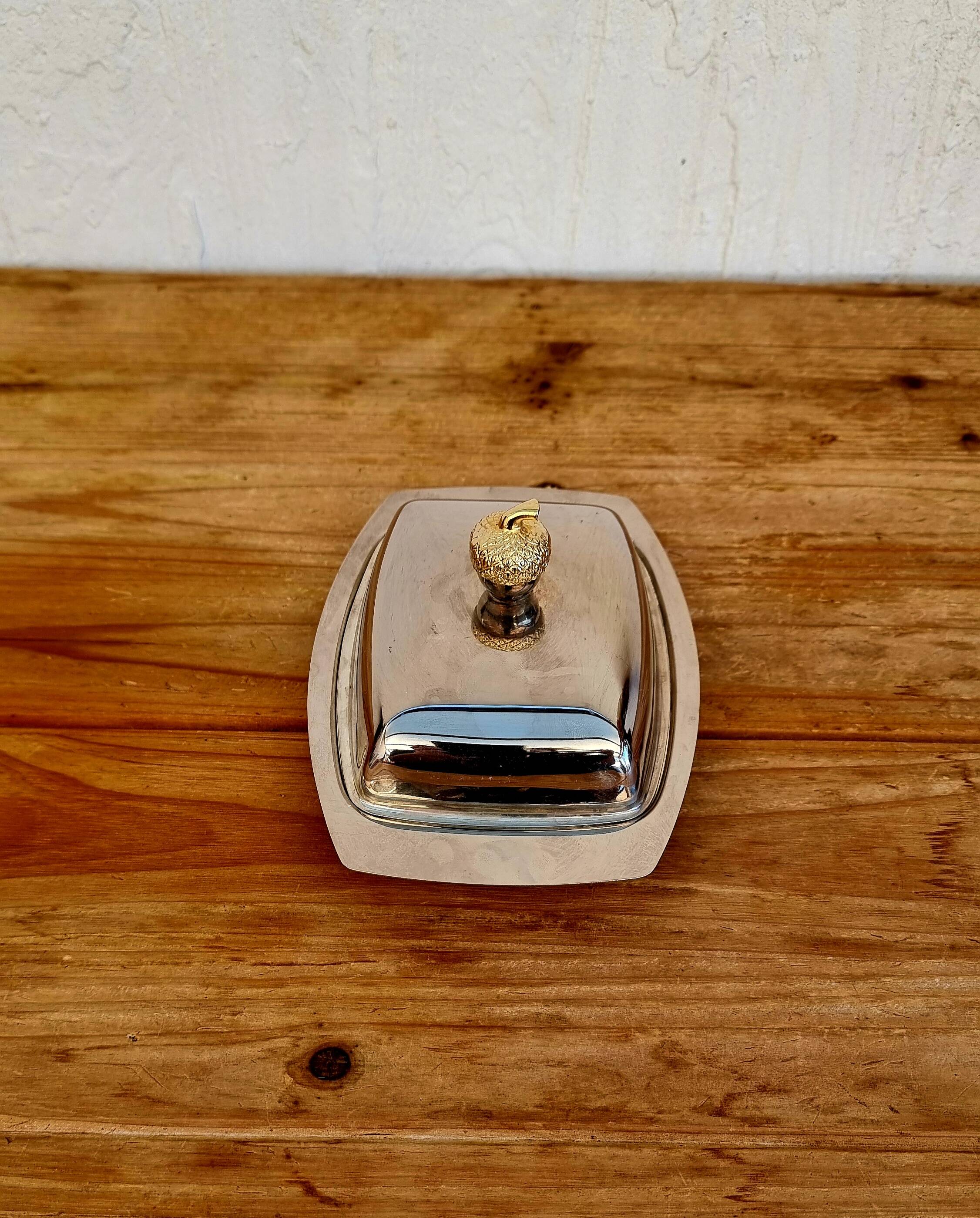 Vintage silver-plated metal butter dish with a gold tassel knob