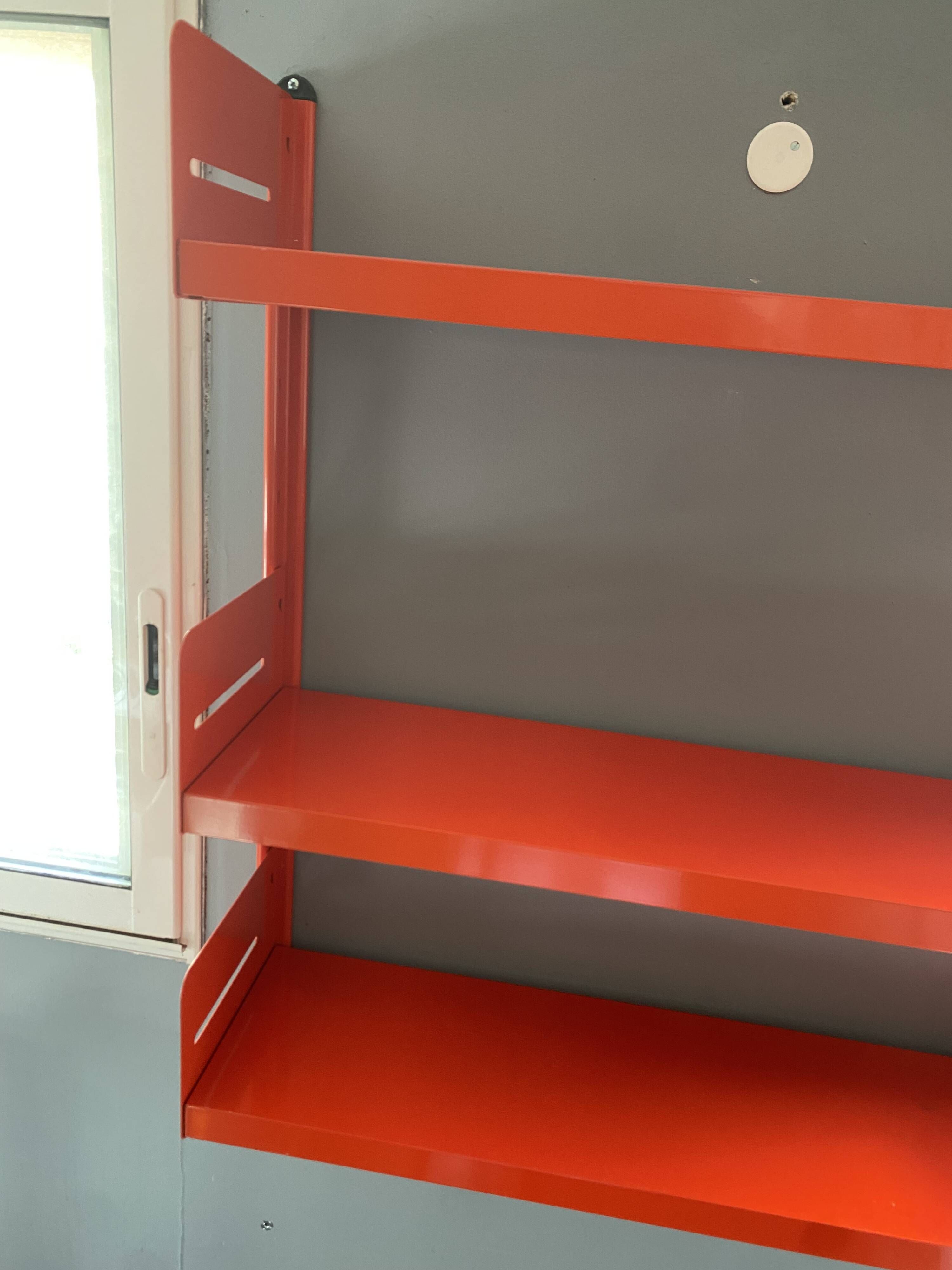 Modular red metal wall shelf in Congresso Lips Vago style.