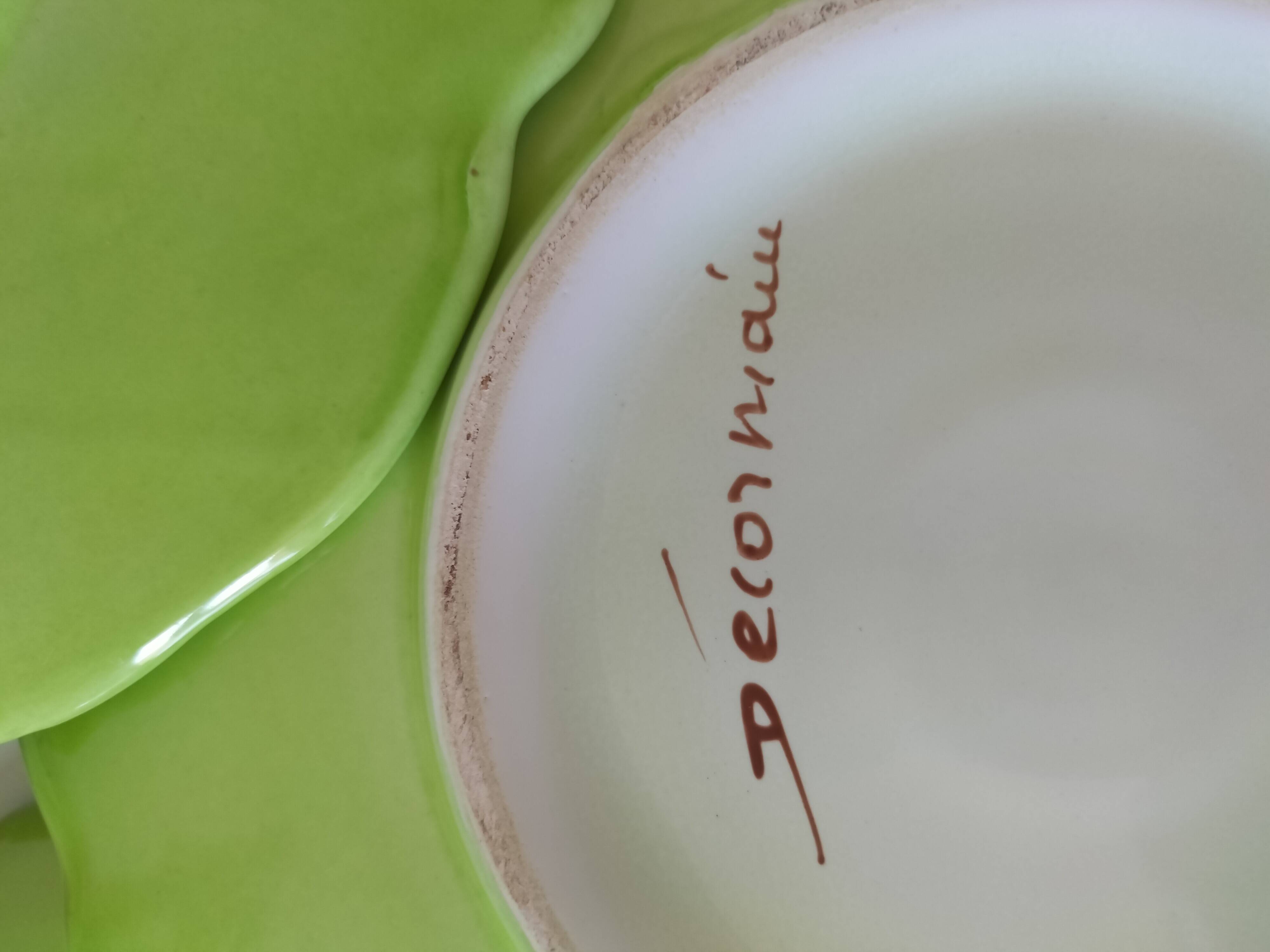 4 hand-decorated earthenware plates with vegetable and green leaf designs.