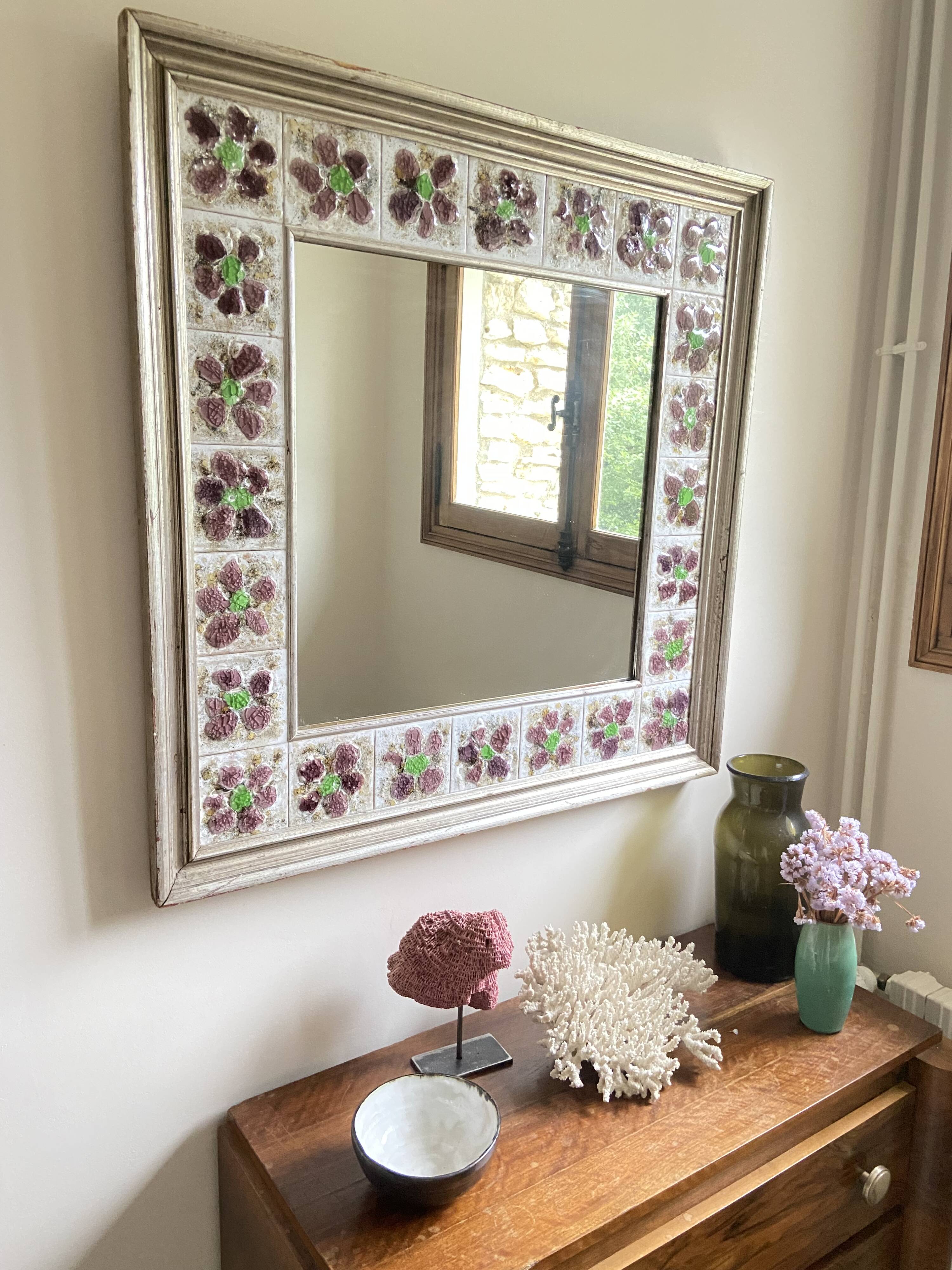 Large square ceramic mirror with floral decoration.