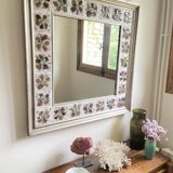 Large square ceramic mirror with floral decoration.