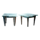 2 tables d'appoint en acier brutaliste avec des motifs de scènes primitives en verre gravé.