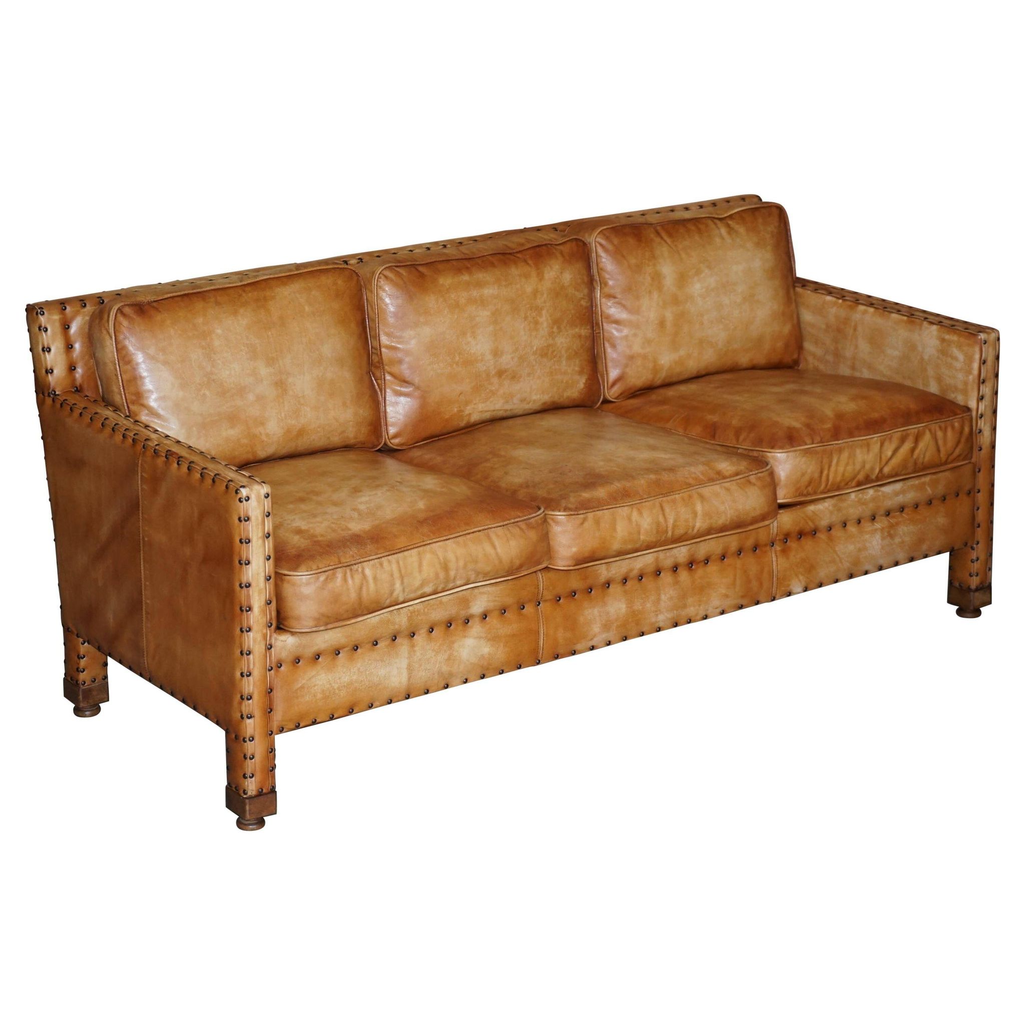 Three-seater leather canapé in Edwardian style with studs.