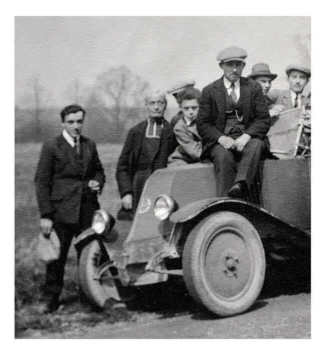 Photograph of a Renault 6CV with 23 admirers including a priest