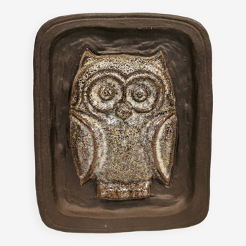 Small relief with a motif of an owl emerging from the back plate.