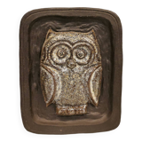 Small relief with a motif of an owl emerging from the back plate.