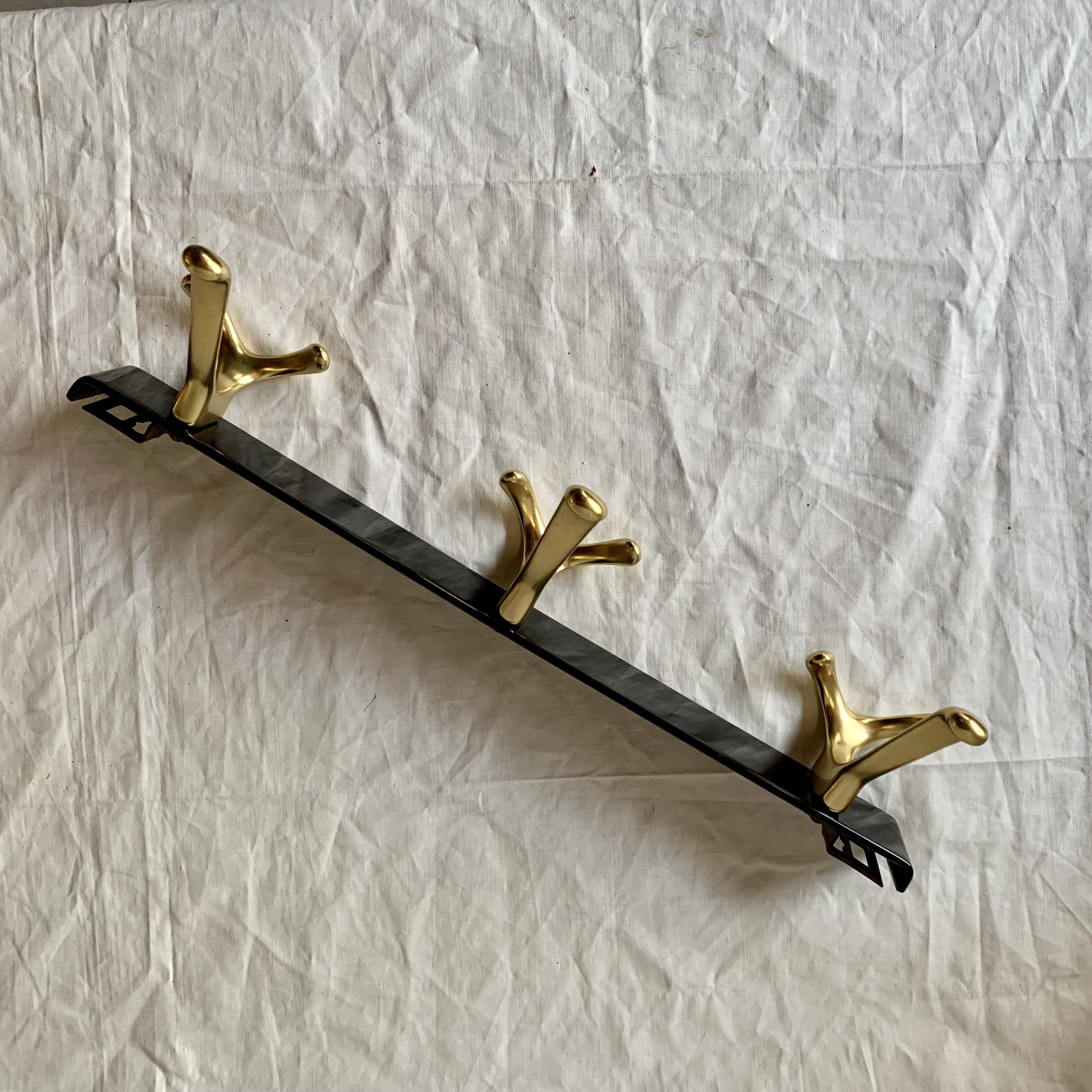 Vintage coat rack in lacquered metal with three golden aluminum hooks