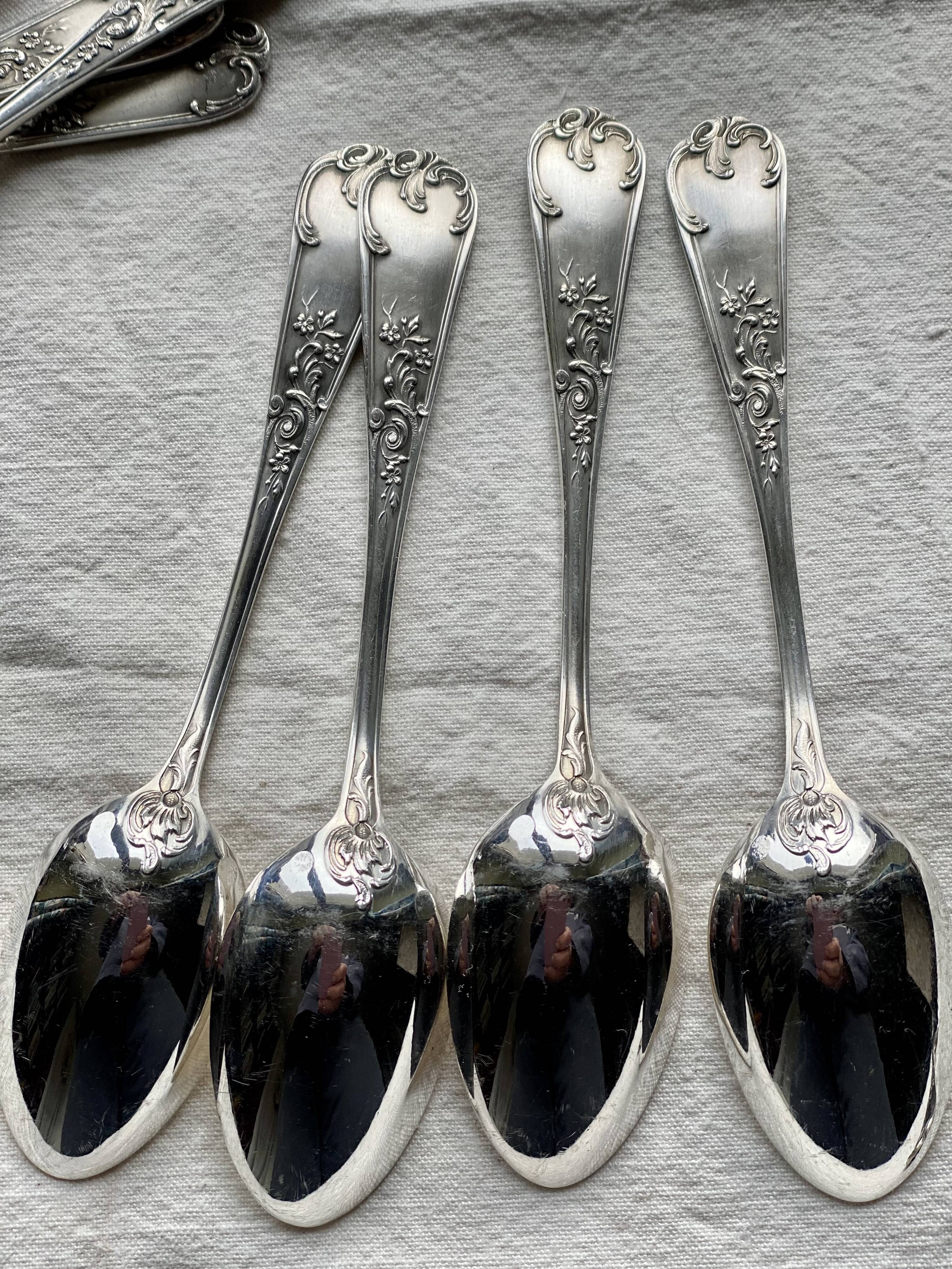 Set of 12 small silver-plated metal spoons in Art Nouveau style.