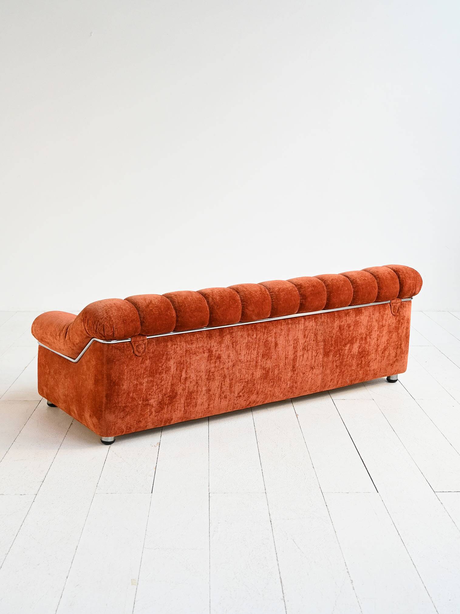 Vintage rust velvet sofa from the 1970s with metal details.