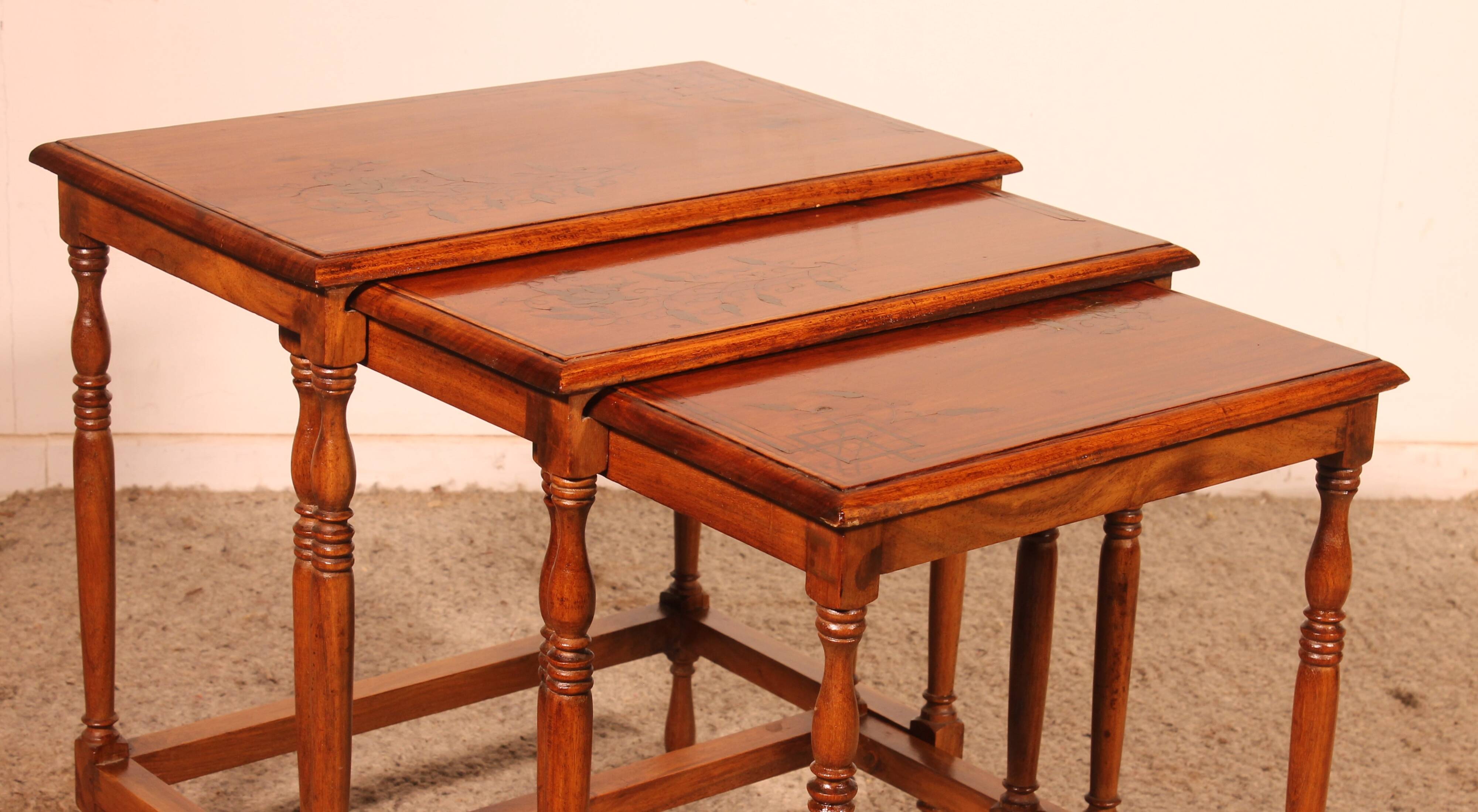 Nested tables in satin wood with brass inlays.