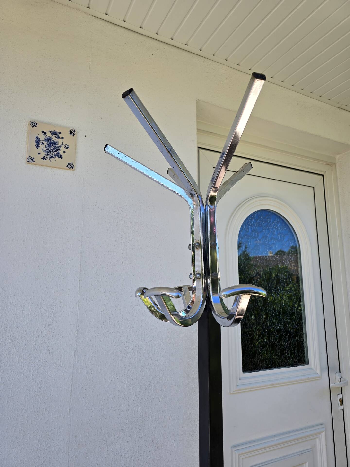 Chrome parrot coat rack with swivel head on a gas lift.