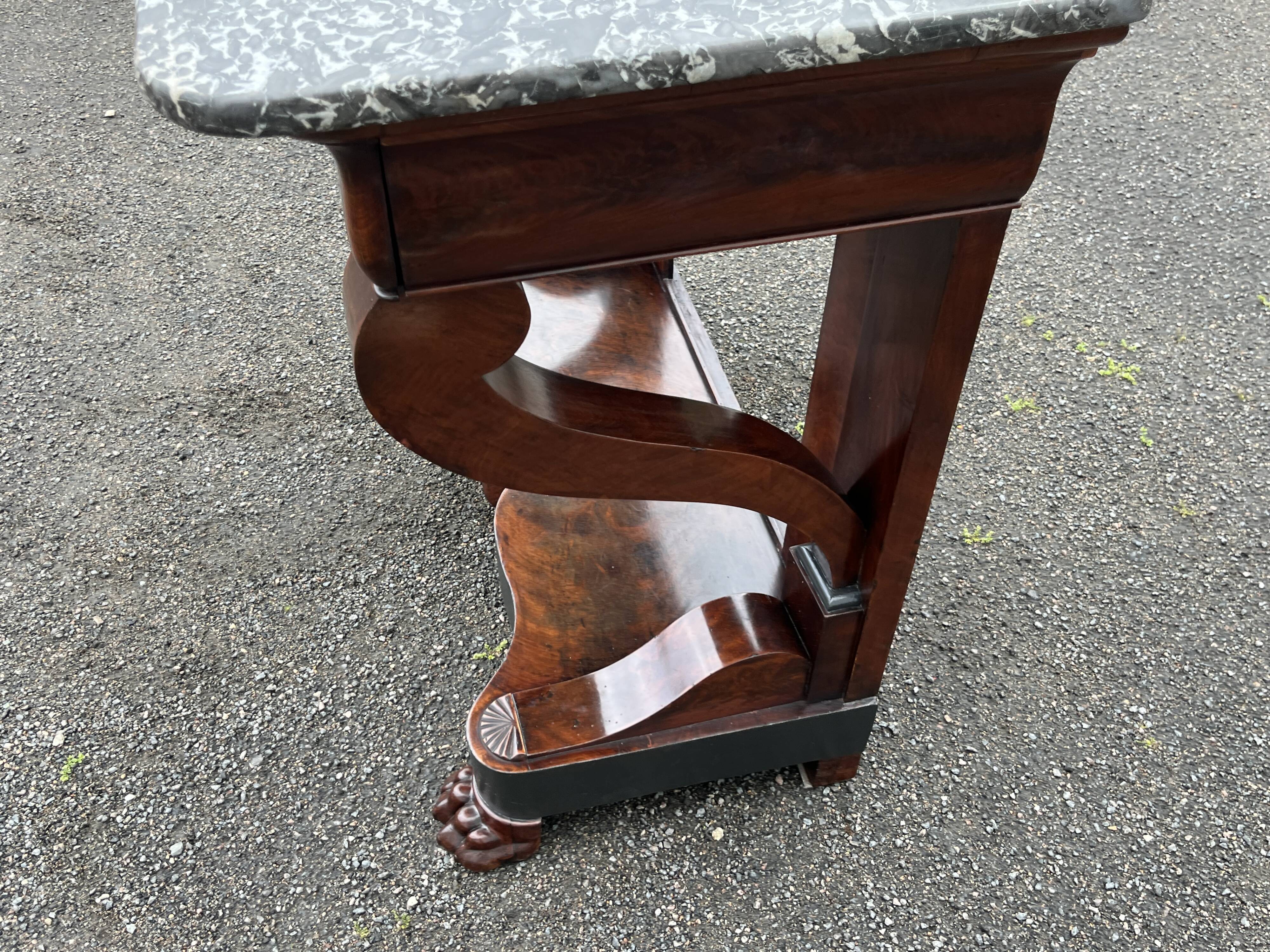 Mahogany console with grey marble top and lion paw feet.