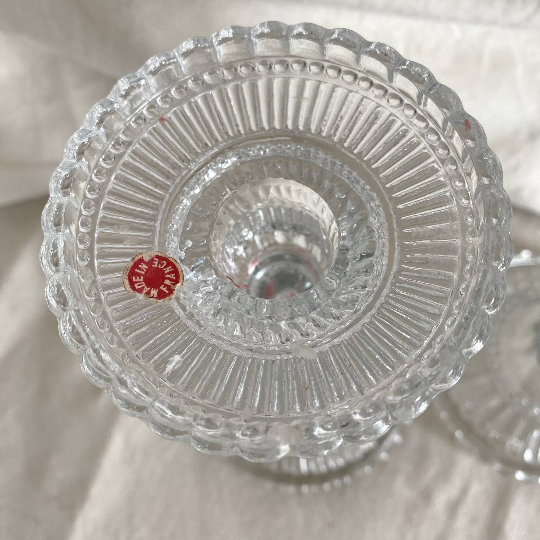 Column candle holders in moulded glass made in France.