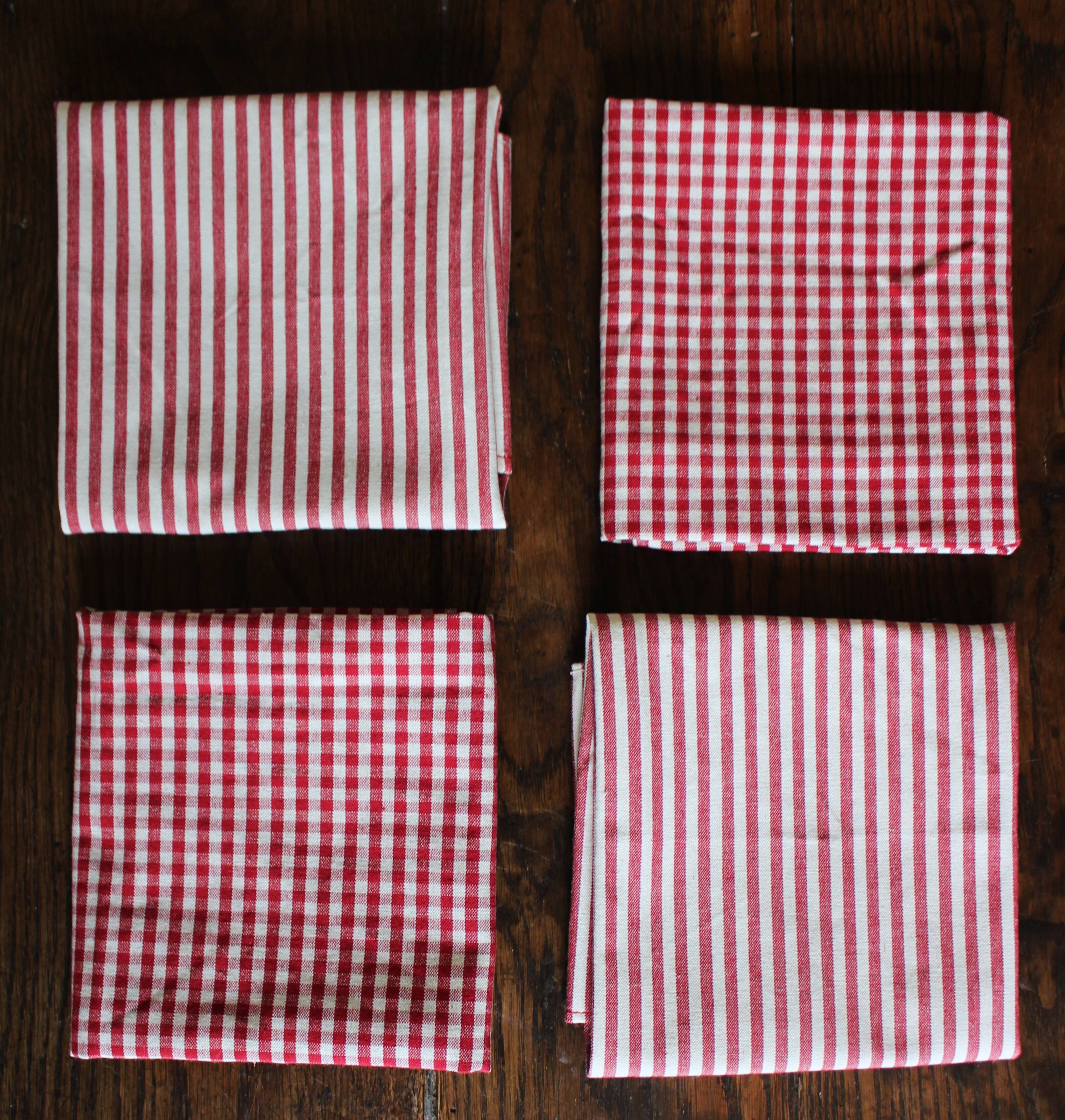 A set of 4 red striped and checkered napkins.