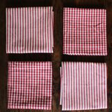 A set of 4 red striped and checkered napkins.