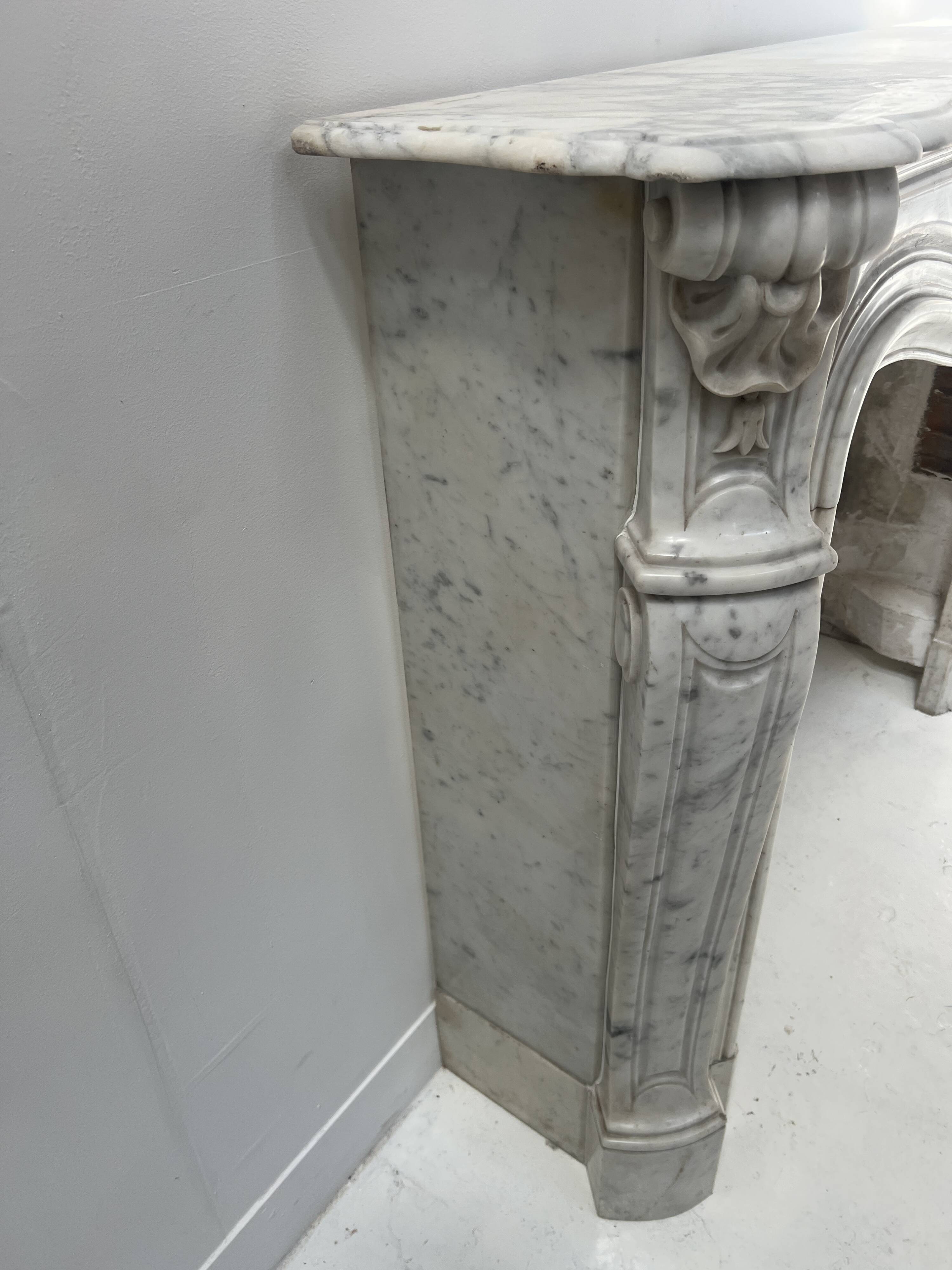 Louis XV style fireplace in veined white Carrara marble, 19th century.