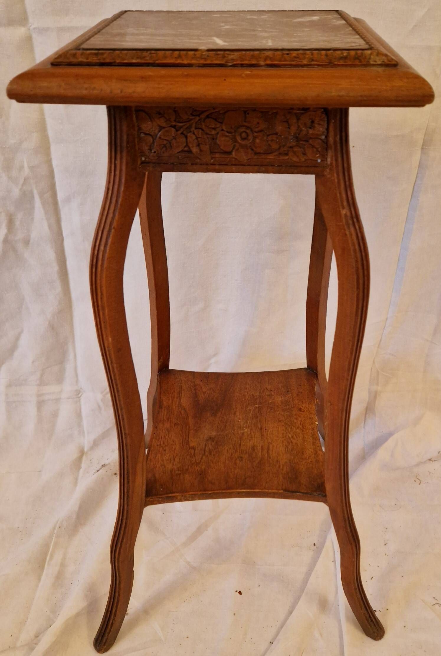 Antique Art Nouveau pedestal table with carved wood and marble top.
