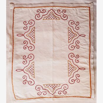 Rectangular placemat, hand-embroidered with a red capital-arabesque motif. 50s.