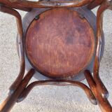 pair of round wooden chairs with a pattern on the seat