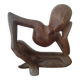 Wooden sculpted statuette of a woman in a pensive pose.