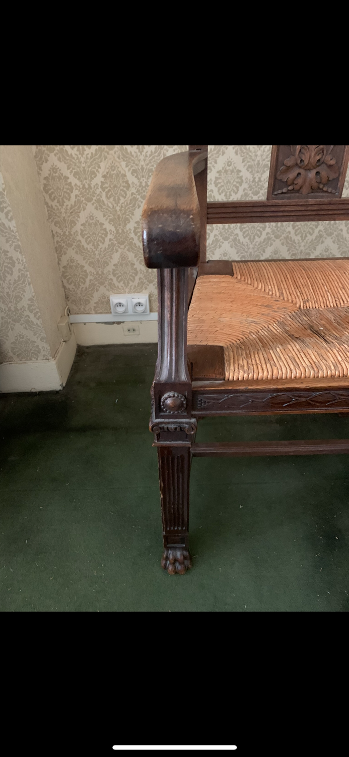 Antique armchair in carved wood with a straw seat.