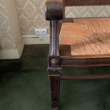 Antique armchair in carved wood with a straw seat.